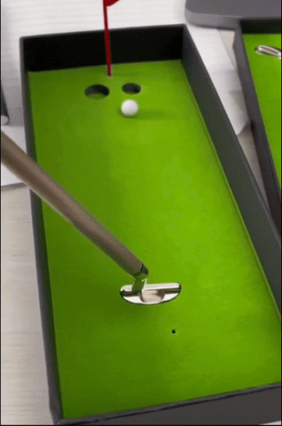 man playing with its desktop golf pen set